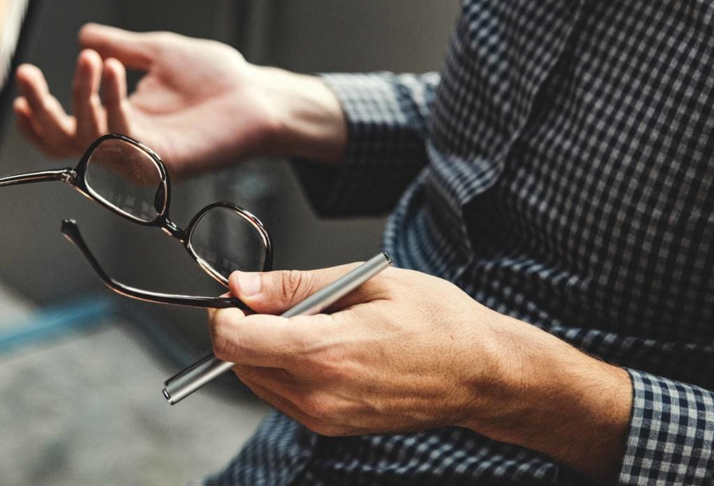 man holding spectacles