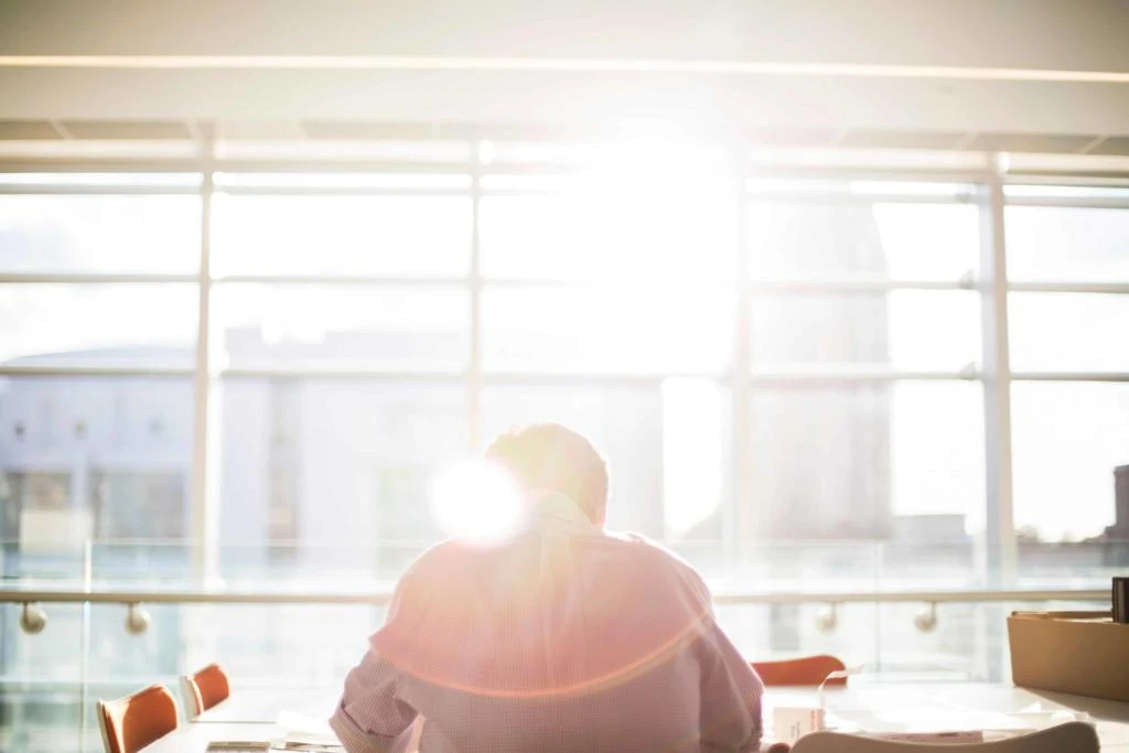 Man sat at desk by windows