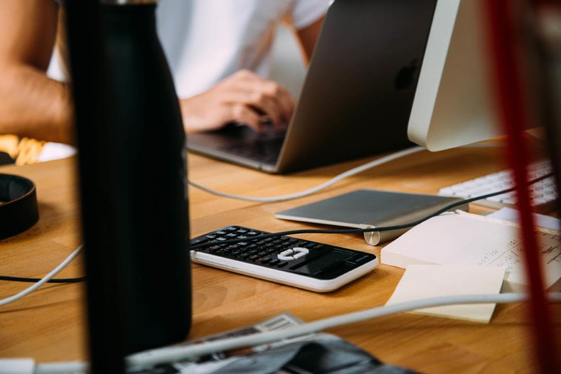 someone using computer and calculator for accounting