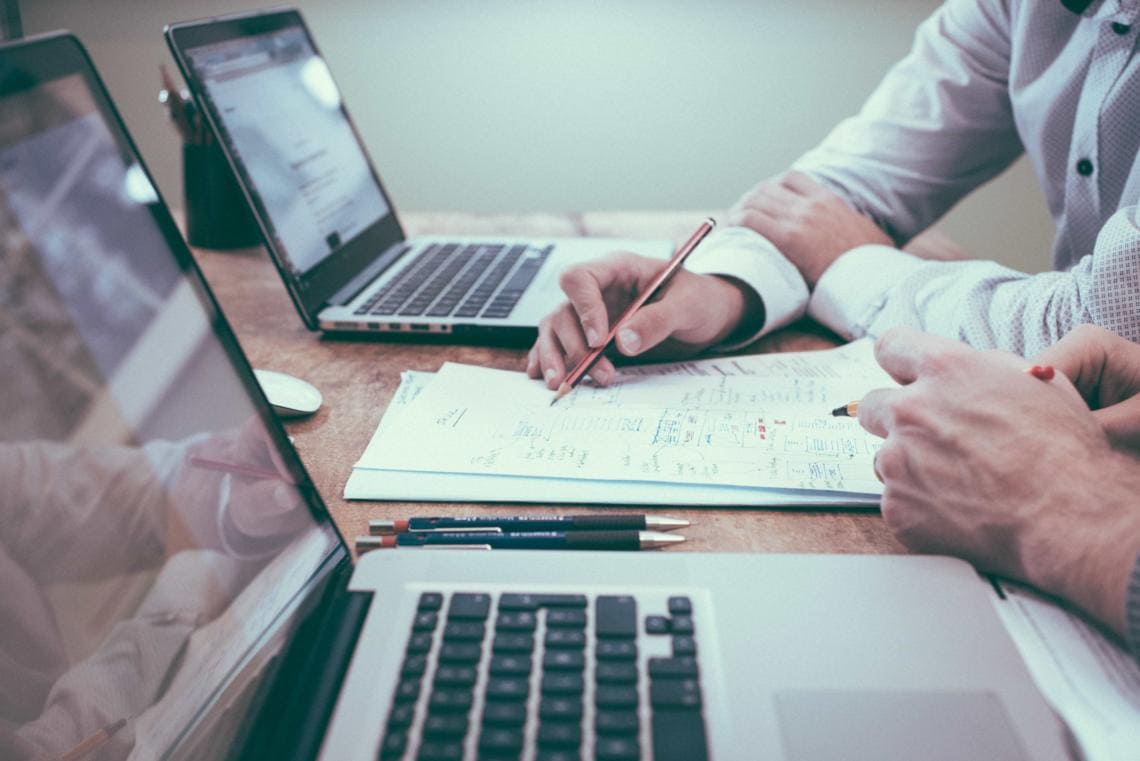 Two IR35 accountants working together on laptops and paper